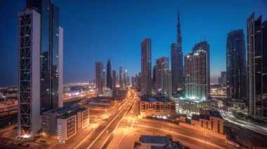 Dubai şehir merkezinin gökyüzü görüntüsü gece gündüz geçiş zamanlarıyla birlikte gökdelendir. Akıllı şehir şehrinde iş alanı trafiği. Gökdelenler ve yüksek binalar güneş doğmadan önce, BAE.