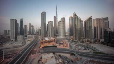 Dubai şehir merkezinin panoramik hava görüntüsü. Günbekten geceye geçiş zamanına kadar pek çok kule var. İş alanı yoğun yol trafiği. Günbatımından sonra gökdelen ve yüksek binalar, BAE