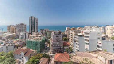 Panorama, Arnavutluk 'un Durres limanı ve şehir merkezinin (eski kent) hava manzarasını gösteriyor. Gökyüzünde bulutlar olan yeşil ağaçlı birçok ev