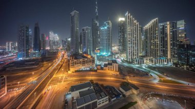 Dubai şehir merkezinin panoramik hava görüntüsü. Günbekten geceye geçiş zamanına kadar pek çok kule var. İş alanı yoğun yol trafiği. Günbatımından sonra gökdelen ve yüksek binalar, BAE