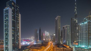 Dubai şehir merkezinin gökyüzü manzarası. Günbegün en yüksek kuleler ve gece geçiş zamanı. Akıllı şehir şehrindeki iş alanı. Günbatımından sonra gökdelen ve yüksek binalar, BAE.