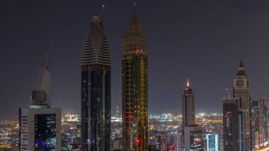 Dubai 'deki Sheikh Zayed Yolu' ndaki gökdelenlerin gökyüzü manzarası tüm gece sürüyor. Uluslararası Finans Merkezi 'nde yukarıdan aydınlatılmış gökdelenler ve ışıklar sönüyor