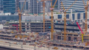 Çalışma saatleri saatlerce değişen vinçleri olan büyük bir inşaat alanı. Business Bay, Dubai 'deki büyük yerleşim ve ofis alanının en iyi hava manzarası