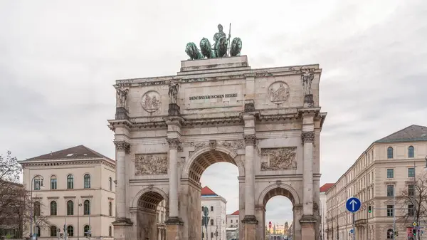 慕尼黑的西格斯特 Siegestor 或胜利门 Victory Gate 是一座纪念拱门 顶部是一座带有狮子四边形的巴伐利亚雕像 纪念碑周围街上的交通情况 前面的景色德国 — 图库照片