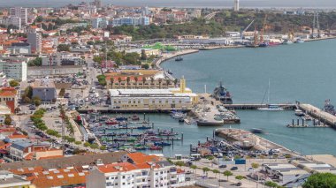 Portekiz, Setubal 'deki marina ve şehir merkezinin hava görüntüsü. Kırmızı çatılar ve kıyı şeridi yukarıdan gelen tekne ve gemilerle. Yolda trafik vardı.