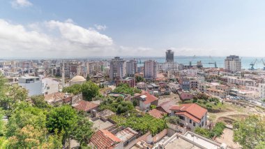 Panorama, Arnavutluk 'un Durres limanı ve şehir merkezinin (eski kent) hava manzarasını gösteriyor. Gökyüzünde bulutlar olan, kırmızı çatıları ve yeşil ağaçları olan birçok ev.