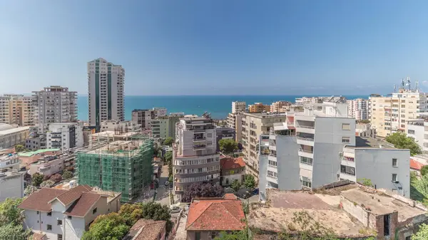 Panorama, Arnavutluk 'un Durres limanı ve şehir merkezinin (eski kent) hava manzarasını gösteriyor. Gökyüzünde bulutlar olan yeşil ağaçlı birçok ev