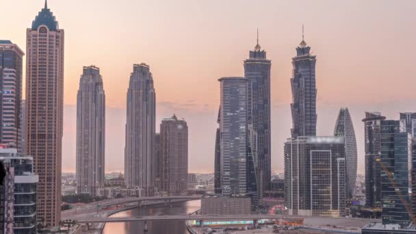 迪拜商业湾的摩天大楼和水渠的城市景观从白天到夜晚都在变化 日落后海滨设有住宅和办公大楼的现代天际线 — 图库视频影像