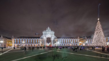 Panorama, Ticaret Meydanı 'nın ışıklandırılmış kemerini ve Lizbon' da Noel zamanında süslenmiş halini gösteriyor. Noel ağacı ve insanların toplandığı bir meydan. Tatil zamanları. Portekiz