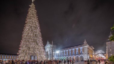 Panorama, Lizbon 'da Noel zamanı Ticaret Meydanı' nın aydınlatıldığını ve süslendiğini gösteriyor. Noel ağacı ve turistlerin cirit attığı bir meydan. Tatil zamanları. Portekiz