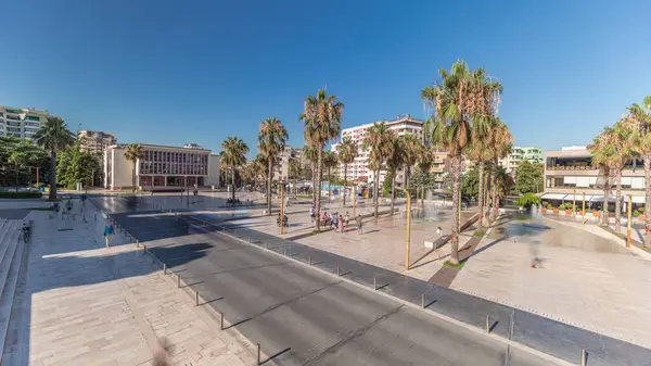 Arnavutluk 'un Durres kentindeki ana meydanında (Sheshi Liria) çeşmelerin ve palmiyelerin havadan görünüşünü gösteren panorama. Sokakta trafik vardı ve insanlar dolaşıyordu.