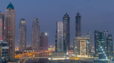 Dubai İşletme Koyu 'nun gökdelenleri ve su kanalı antenleri olan şehir manzarası. Gece gündüz geçiş zamanı. Gündoğumundan önce rıhtımda konut ve ofis kuleleri olan modern gökyüzü.