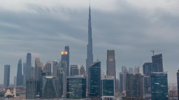 迪拜商业湾和下城的空中景观 以及运河两岸的摩天大楼和塔楼 从白天到夜晚的过渡时间 日落后有起重机的建筑工地 多云啊 — 图库视频影像