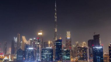 Tüm gece boyunca Dubai Business Bay ve Downtown 'ın havadan görüntüsü. Kanal boyunca çeşitli gökdelenler ve kuleler var. Vinçleri olan bir inşaat alanı. Bulutlar ve sis