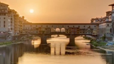 Florence Timelapse, İtalya 'daki Arno Nehri üzerindeki Florence Ponte Vecchio' nun günbatımı manzarası. Floransa mimarisi. Floransa 'nın ana simgelerinden biri.