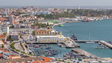 Portekiz, Setubal 'deki marina ve şehir merkezinin hava görüntüsü. Kırmızı çatılar ve kıyı şeridi yukarıdan gelen tekne ve gemilerle. Yolda trafik vardı.
