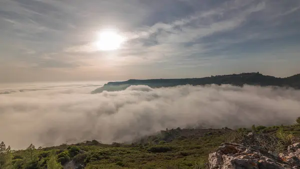 stock image Panorama showing aerial View of Sesimbra Town and Port covered by fog timelapse, Portugal. Top landscape above the clouds and setting sun. Resort in Setubal district