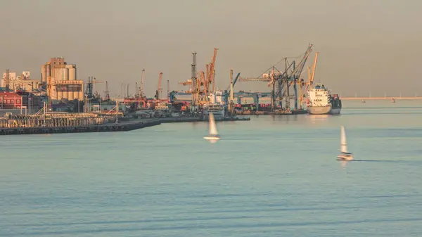 クレーンが付いている産業港のドッキングの間に容器の貨物船 輸出商業貿易ビジネスロジスティックと輸送 ポルトガルのリスボンでの夕日中のテジ川 — ストック写真