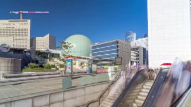 La Defence zaman atlaması panoraması, yüksek gökdelenleri binaları ve metro istasyonundan çıkışında ısıtıcıları olan iş ve finans bölgesi.
