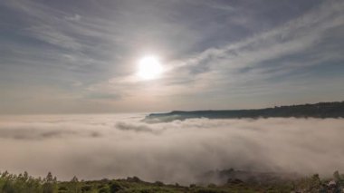 Panorama, Portekiz 'deki Sesimbra Town ve Port' un sisli zaman dilimi ile kaplı hava görüntüsünü gösteriyor. Bulutların tepesindeki manzara ve batan güneş. Setubal ilçesinde tatil köyü