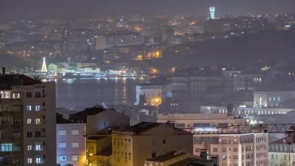 夜のタイムラプスのダウンタウンのリスボの空中ビュー バイサのパノラマ ロッシオ チアドの屋上から イルミネーションされた建物 テジ川の向こう側にあるアルマダ ポルトガル — ストック動画