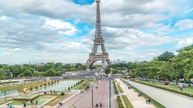 Trocadero Meydanı 'ndaki fıskiyeler ve arka planda Eyfel Kulesi. Trocadero ve Eyfel Kulesi Paris 'in en çok ziyaret edilen yerleridir. Yaz günü bulutlu bir gökyüzü. Yol ayrımında trafik