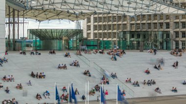 Büyük merdivenler ve üzerinde oturan insanlar Paris, Fransa 'nın savunma iş bölgesinde saatlerini ayarlıyorlar. Yukarıdan yukarıdan bir görüntü. Yürüme alanında dinleniyor.