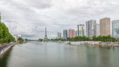 Eyfel Kulesi ve Özgürlük Anıtı modern binalar ve yol trafiği yüksek hızda giderken suya yansıdı. Gün batımından önce Mirabeau Köprüsü 'nden görüntü. Paris, Fransa