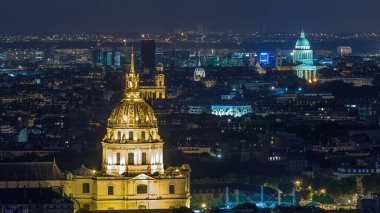 Aerial Night timelapse view of Paris City and Les Invalides golden dome shot on the top of Eiffel Tower observation deck. Evening illumination. clipart