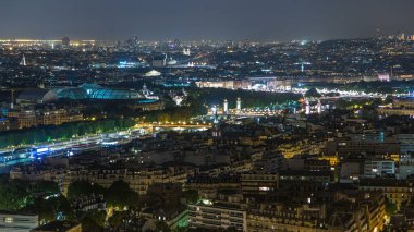 Paris City ve Seine nehrinin Eiffel Kulesi gözlem güvertesinin tepesinde çekilmiş gece görüntüsü. Alexandre Köprüsü 'nün akşam aydınlanması