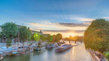 Fransa 'nın Pont Neuf kentinden gün batımında Paris' teki Pont des Arts 'ın hava görüntüsü. Vert-Galant 'ın karesine yakın Seine Nehri' nde bir gemi.