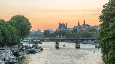 Paris 'te Pont des Arts, gün batımından sonra Pont Neuf, Fransa' dan geçiş zamanı. Seine Nehri 'ndeki gemi Vert-Galant' ın meydanına yakın. Yukarıdan su üzerindeki yansıma ile görüntüle