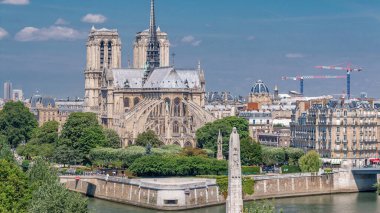 Paris, Cite Adası ve Katedral Notre Dame de Paris ile birlikte Arap Dünya Enstitüsü gözlem güvertesinin arka planında. Üst Manzara. Yeşil ağaçlar, yaz gününde mavi bulutlu gökyüzü. Fransa.