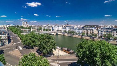 Cite Island ve Katedral Notre Dame de Paris ile Paris Panoraması Arap Dünya Enstitüsü gözlem güvertesinden bir zaman arkaplanı üzerinde. Üst Manzara. Yeşil ağaçlar, Seine nehri, mavi bulutlu gökyüzü. Fransa