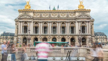 Palais veya Opera Garnier Ulusal Müzik Akademisi Paris, Fransa 'da ön gösterim zamanı. İnsanlar sokakta dolaşıp, trafiği seyrediyor. Metro girişi.