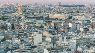 Paris 'teki evlerin çatılarının üstündeki hava panoraması gece gündüz geçiş zamanı. Günbatımından sonra aydınlanan gece manzarası, kiliseler ve diğer manzaralar.