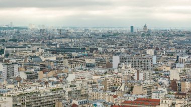 Paris 'te bir zaman diliminde çatıların üstündeki evlerin üstündeki hava manzarası. Sabahları gökyüzü bulutlu, ana manzaralı.