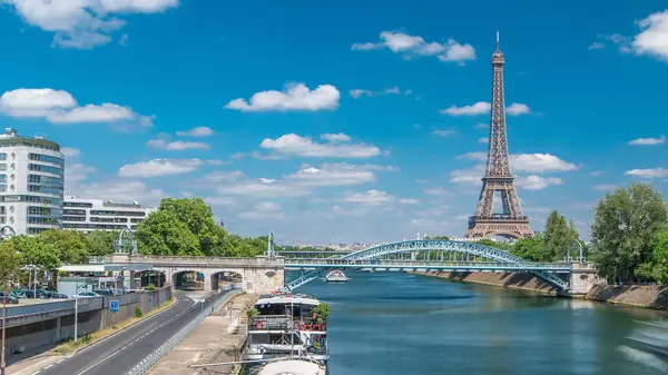 埃菲尔铁塔位于塞纳河畔 距离法国巴黎的格雷诺尔桥很远 在阳光明媚的夏日 天鹅岛和大船在河上航行 街上交通繁忙 拱形刚毛在水面上 — 图库照片