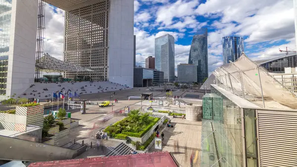 stock image Square and modern skyscrapers timelapse hyperlapse in the Defence business district of Paris, France. Blue cloudy sky at summer day. Top view from above