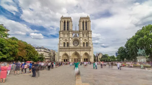 Notre-Dame de Paris 'in ön görüntüsü. Fransa, Paris 'teki Cite Adası' ndaki ortaçağ Katolik katedrali. Girişte uzun bir turist kuyruğu var. Yaz gününde bulutlu bir gökyüzü