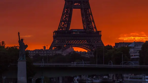 埃菲尔铁塔的日出时间在塞纳河和法国巴黎与船同行 从米拉博大桥看风景 左边的自由女神像橙色天空 — 图库照片