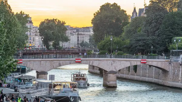 セーヌ川のウォーターフロントとノートルダム パリ大聖堂の近くの橋昼から夜への移行は日没後に経過します トンネル橋からの眺め 背景にオレンジの空 フランス ヨーロッパ — ストック写真