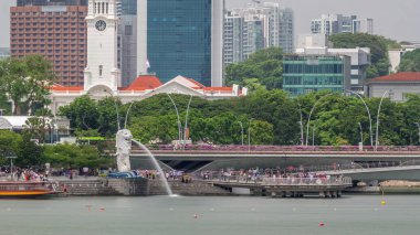 Singapur Merlion Parkı ve Victoria Konser Salonu 'nda da Escplanade Köprüsü zaman dilimi var. İnsanlar yolda yürüyor ve trafikte yürüyor.