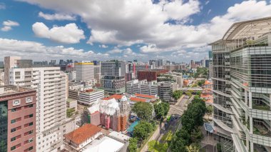 Singapur silueti, Victoria caddesi ve Ulusal Kütüphane hava zaman çizelgesi. Trafiği olan yeşil ağaçlar. Mavi gökyüzünde bulutlar