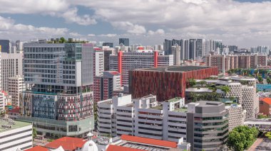 Singapore skyline with Victoria street and shopping mall aerial timelapse. Green trees on the road with traffic. Clouds on a blue sky clipart