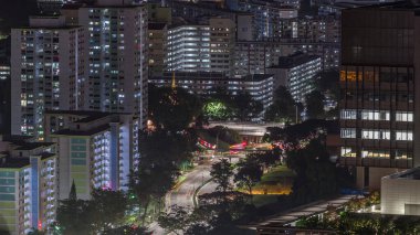 Singapur 'da gece vakti gökdelenleri ve apartman binaları olan gökdelenler. Sokakta trafik vardı. Skybridge bakış açısından bak