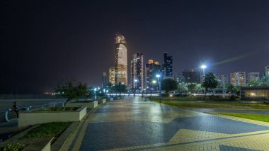 Abu Dabi 'deki gökdelenler gece vakti gökdelenler hiperhızlandırılmış, Birleşik Arap Emirlikleri. Aydınlatılmış modern kulelerle Corniche 'den görüntü