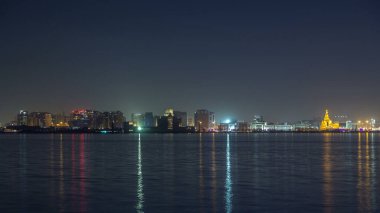 Ortadoğu Katar 'da gece aydınlatılan İslam Kültür Merkezi zaman çizelgesiyle Doha silueti. Batı Körfezi 'nden görüntüle