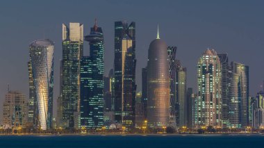 Arap şehri Doha 'nın ufuk çizgisi gece gündüz Katar' daki geçiş zamanı, gün doğumundan hemen önce aydınlık gökdelenlerle yakalandı. Corniche Gezinti Alanından Görünüm