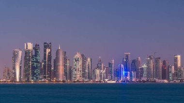 Arap şehri Doha 'nın ufuk çizgisi gece gündüz Katar' daki geçiş zamanı, gün doğumundan hemen önce aydınlık gökdelenlerle yakalandı. Corniche Gezinti Alanından Görünüm
